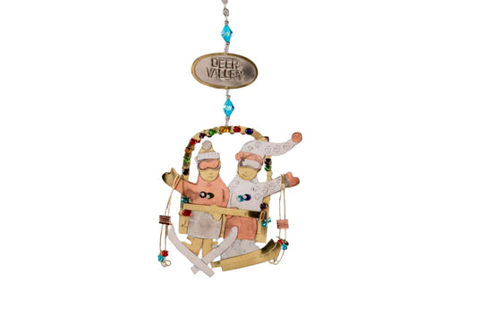 Mixed metal ornament with two skiers on a chairlift