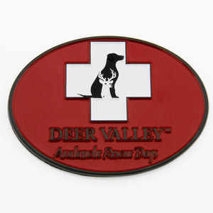 A red oval shaped magnet featuring the Deer Valley avalanche rescue dog logo